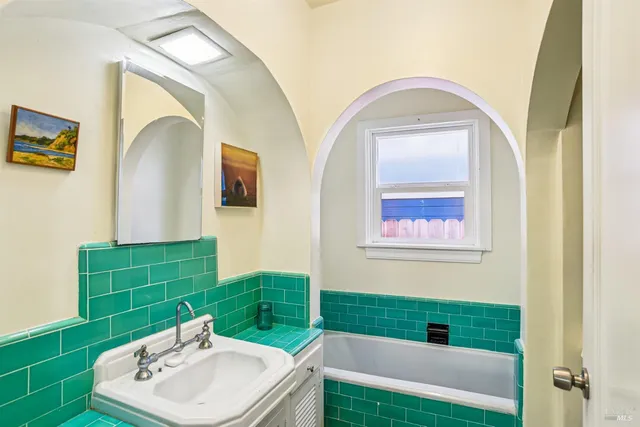 a bathroom with a sink mirror and tub