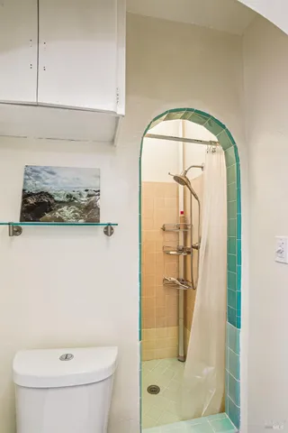 a bathroom with a toilet and a shower