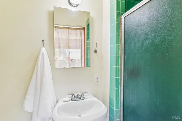 a bathroom with a sink and mirror with window