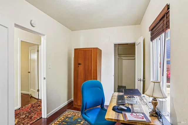 a view of a workspace with furniture and a window