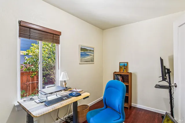 a view of a workspace with furniture and a window