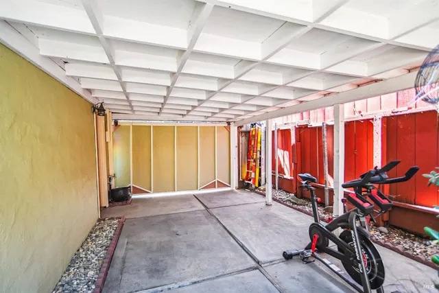 a view of an empty room with wooden floor and windows