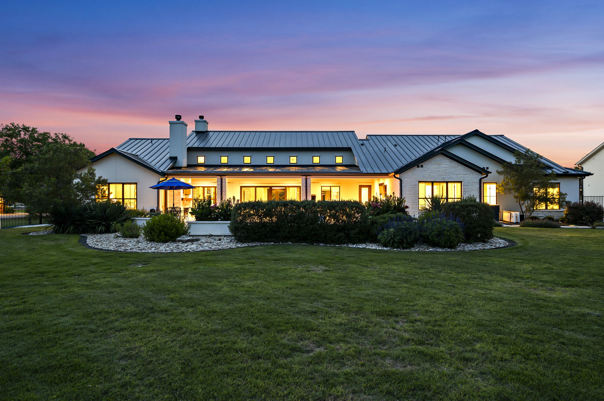 811 Wade Road Canyon Lake, TX 78132 - Photo 37 of 40 Back of house featuring a standing seam roof, a chimney, and a lawn