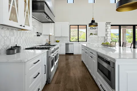 a kitchen with a stove a sink and a window