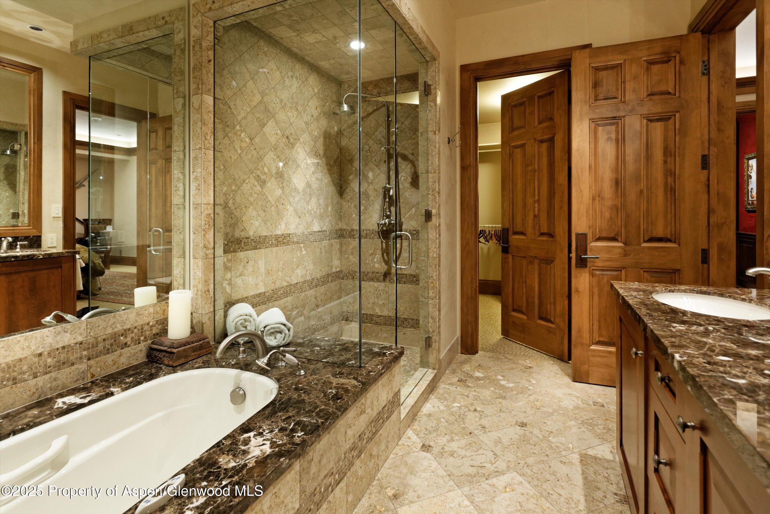 220 Buttermilk Lane Aspen, CO 81611 - Photo 16 of 60 a bathroom with a granite countertop tub sink a mirror a vanity and shower