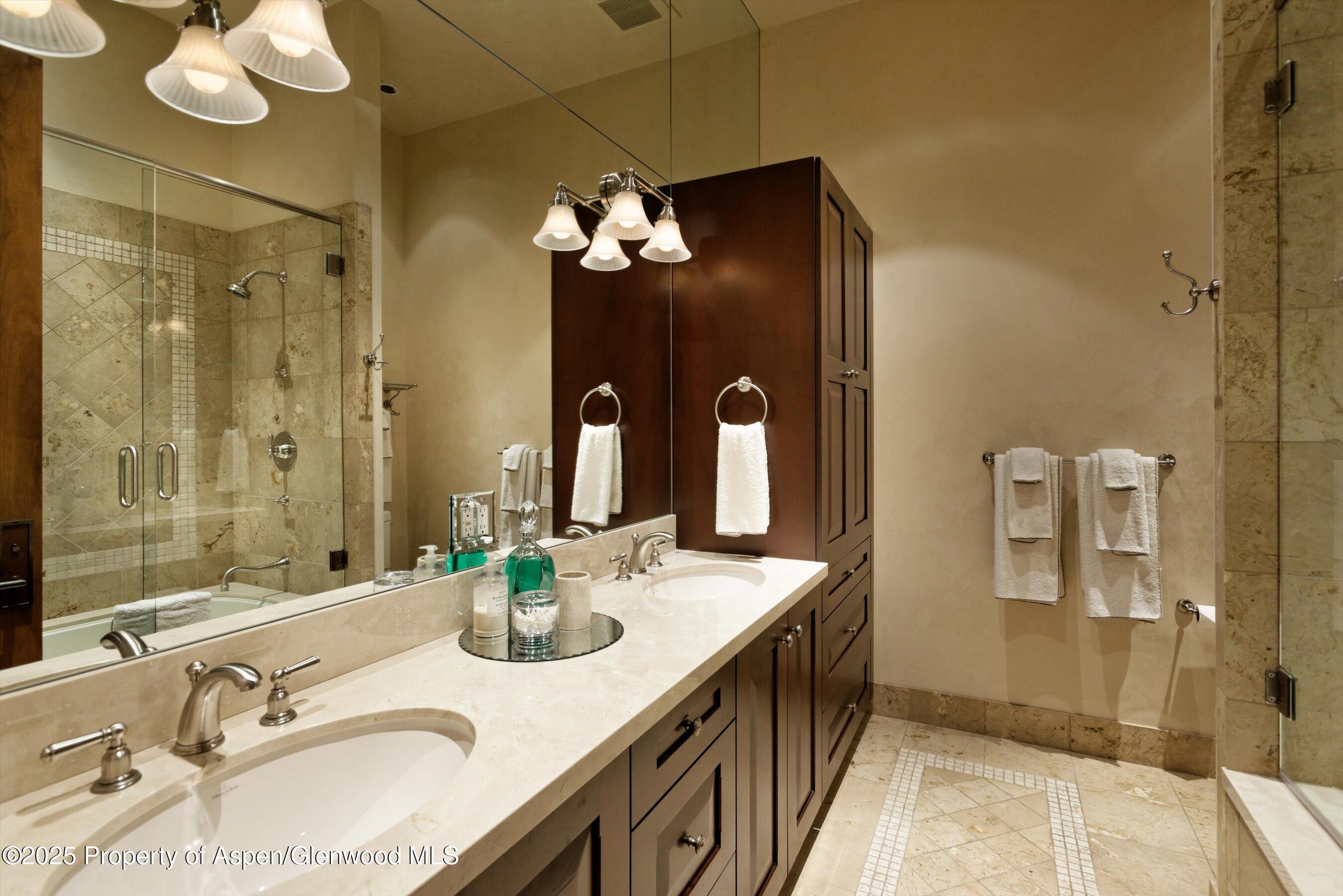 220 Buttermilk Lane Aspen, CO 81611 - Photo 17 of 60 a bathroom with a granite countertop sink a large mirror and a shower