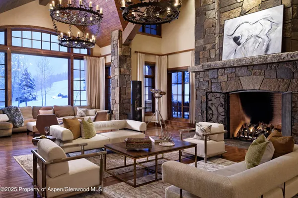 a spacious bedroom with a bed a couch and a chandelier