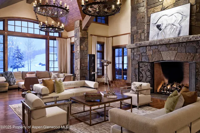 a spacious bedroom with a bed a couch and a chandelier