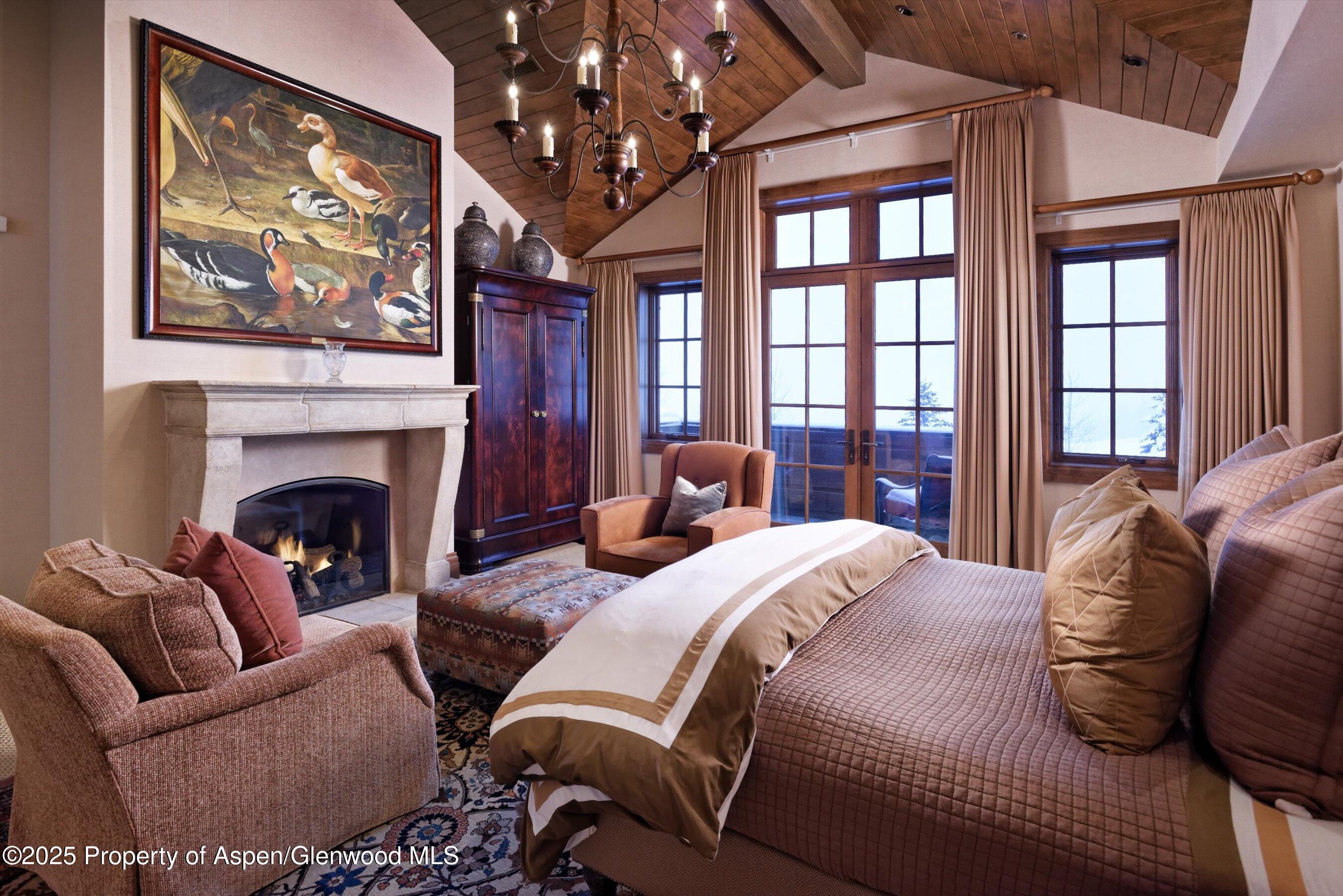 220 Buttermilk Lane Aspen, CO 81611 - Photo 30 of 60 a bedroom with a large bed and a fireplace