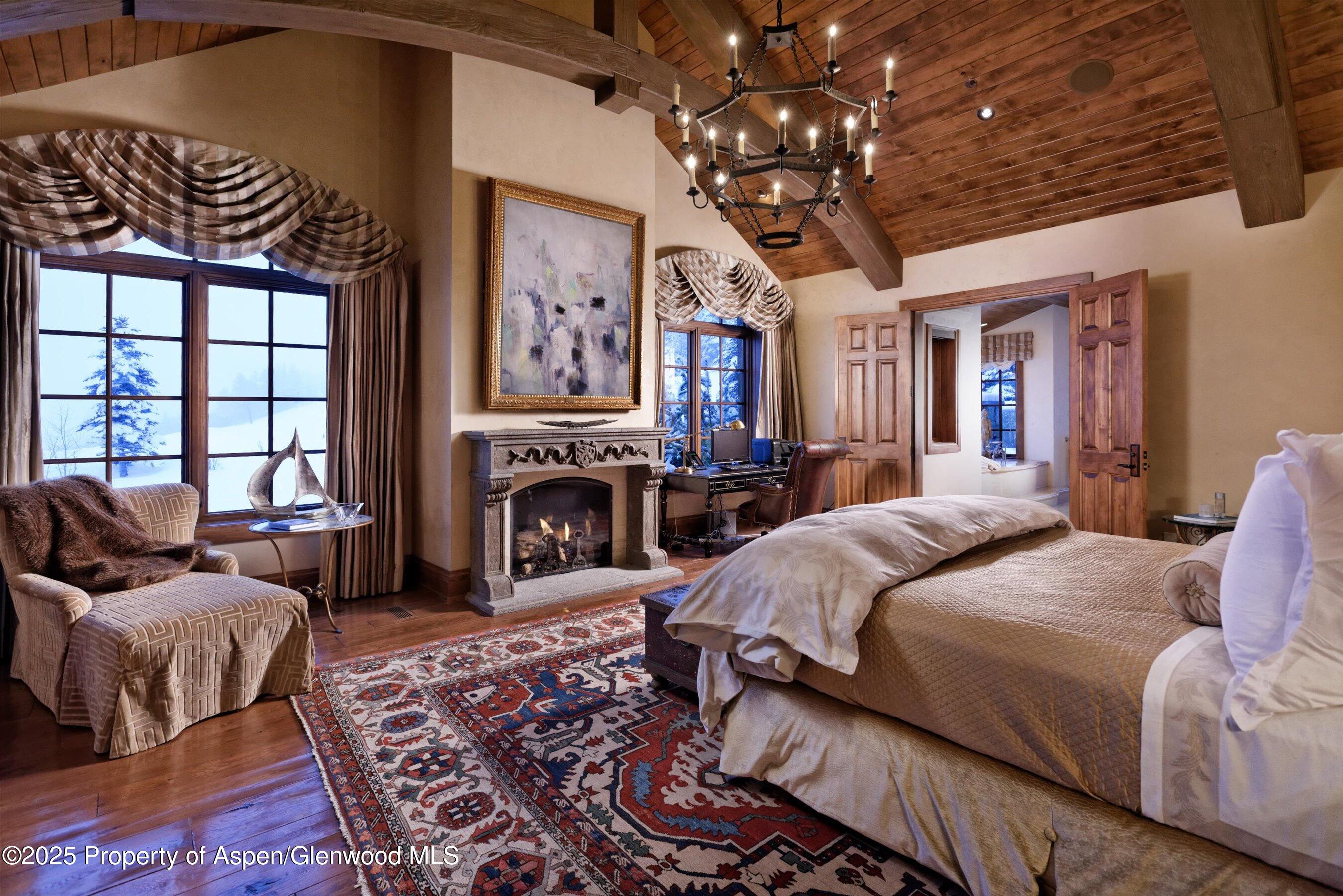 220 Buttermilk Lane Aspen, CO 81611 - Photo 4 of 60 a spacious bedroom with a bed a couch and a chandelier