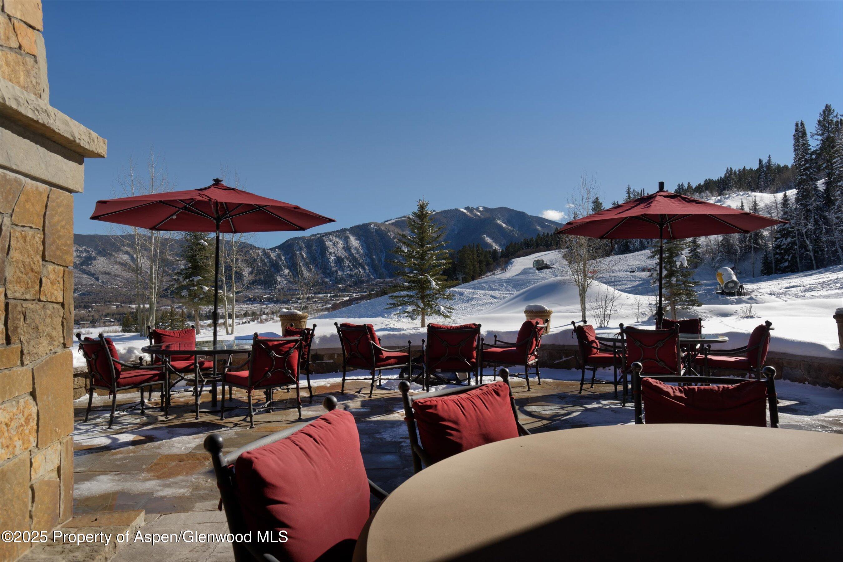 220 Buttermilk Lane Aspen, CO 81611 - Photo 45 of 60 a view of a patio with a dining table and chairs under an umbrella
