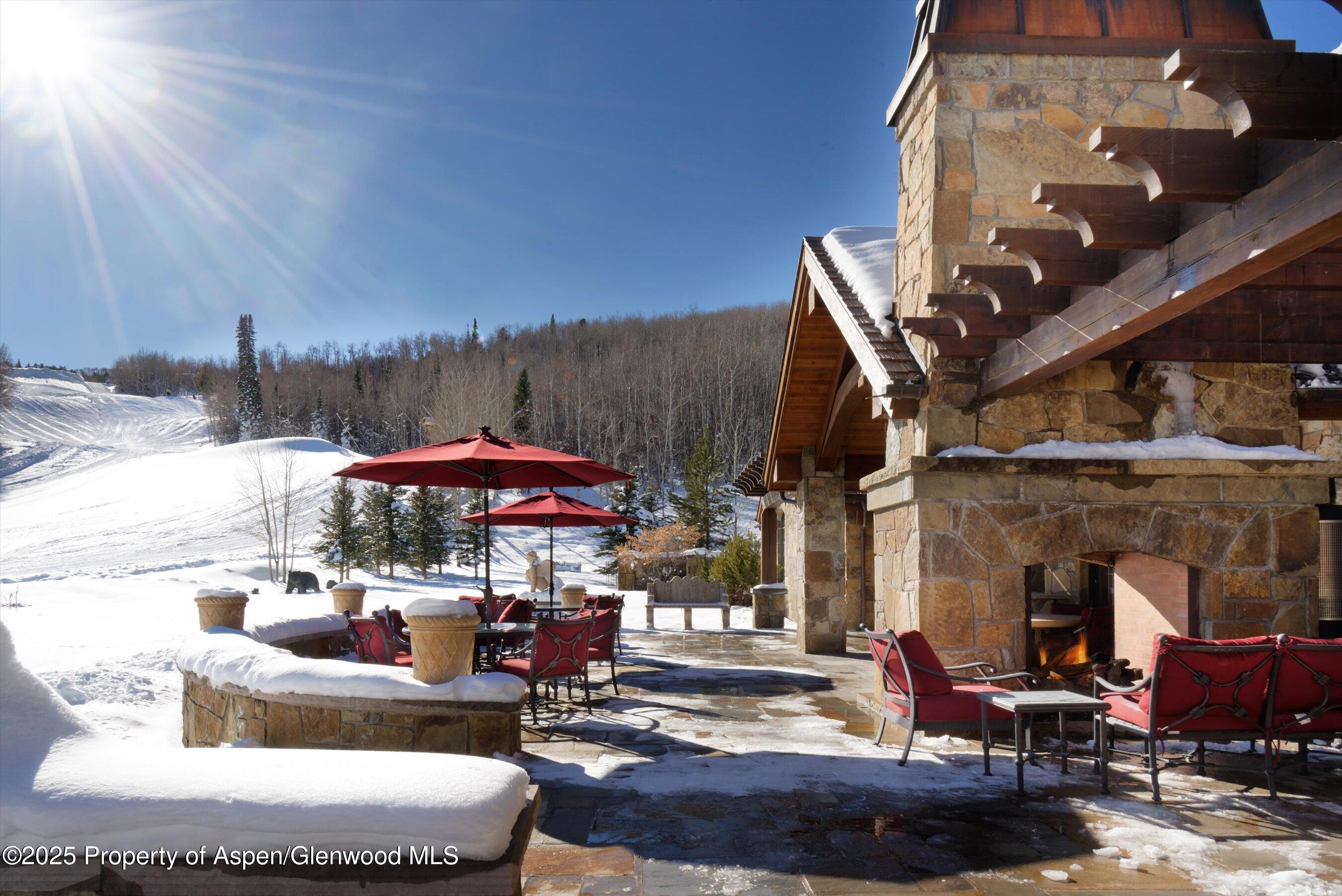 220 Buttermilk Lane Aspen, CO 81611 - Photo 50 of 60 a patio with water fountain and a fire pit