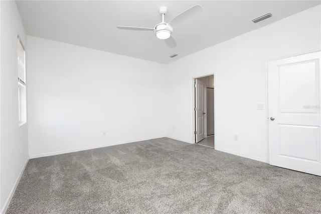 an empty room with fan and entrance
