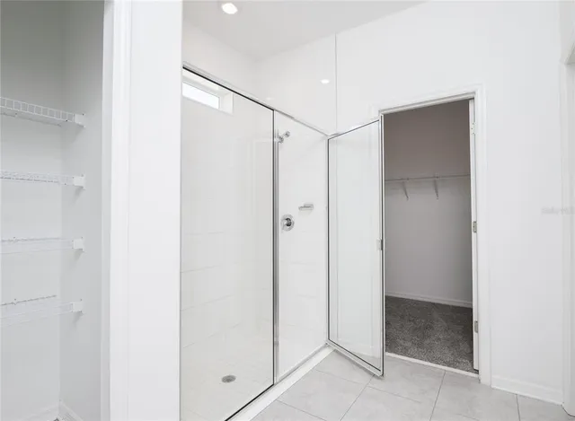 a bathroom with a shower and a glass door