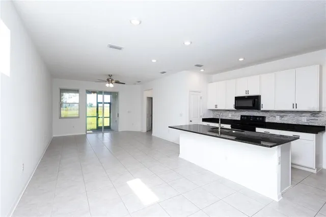 a kitchen with stainless steel appliances granite countertop a sink and a stove top oven