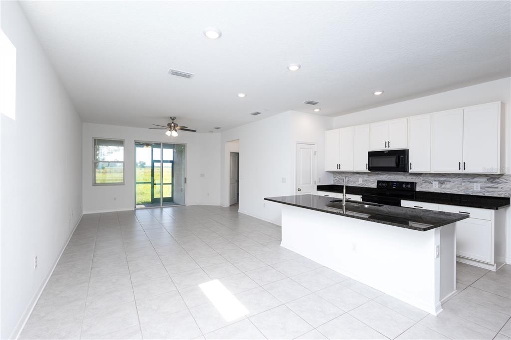 11851 Brighton Knoll Loop Riverview, FL 33579 - Photo 5 of 28 a kitchen with stainless steel appliances granite countertop a sink and a stove top oven