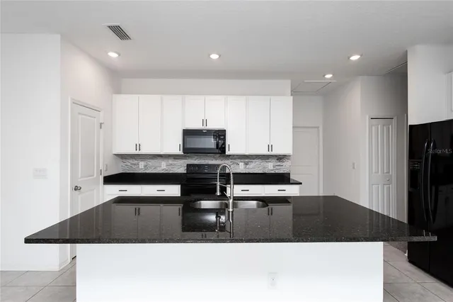 a kitchen with stainless steel appliances kitchen island sink refrigerator and stove