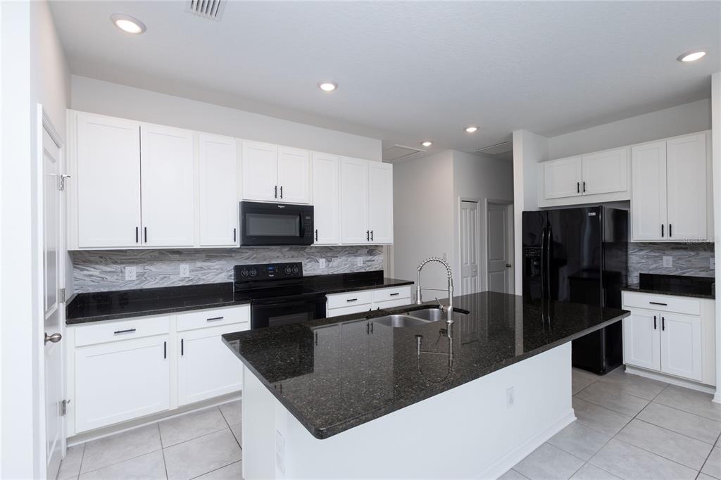 11851 Brighton Knoll Loop Riverview, FL 33579 - Photo 8 of 28 a kitchen with stainless steel appliances granite countertop a sink a stove and refrigerator