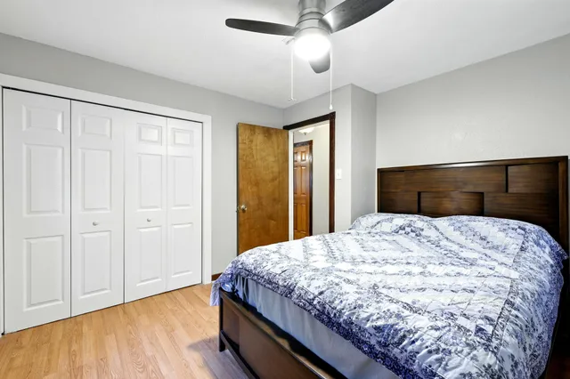 a bedroom with a bed and wooden floor