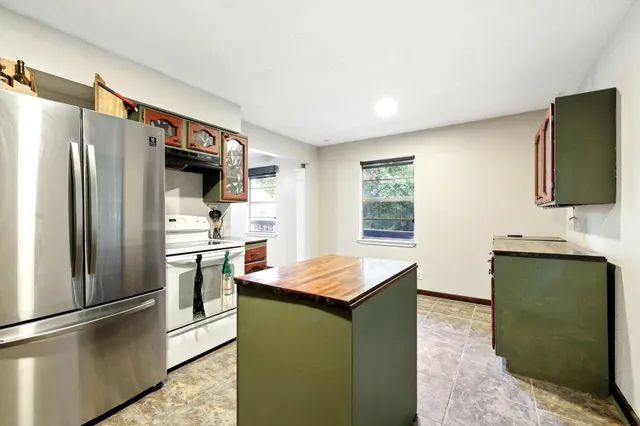 a kitchen with stainless steel appliances granite countertop a refrigerator and a stove