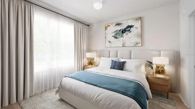 a bedroom with a large bed and a painting on the wall