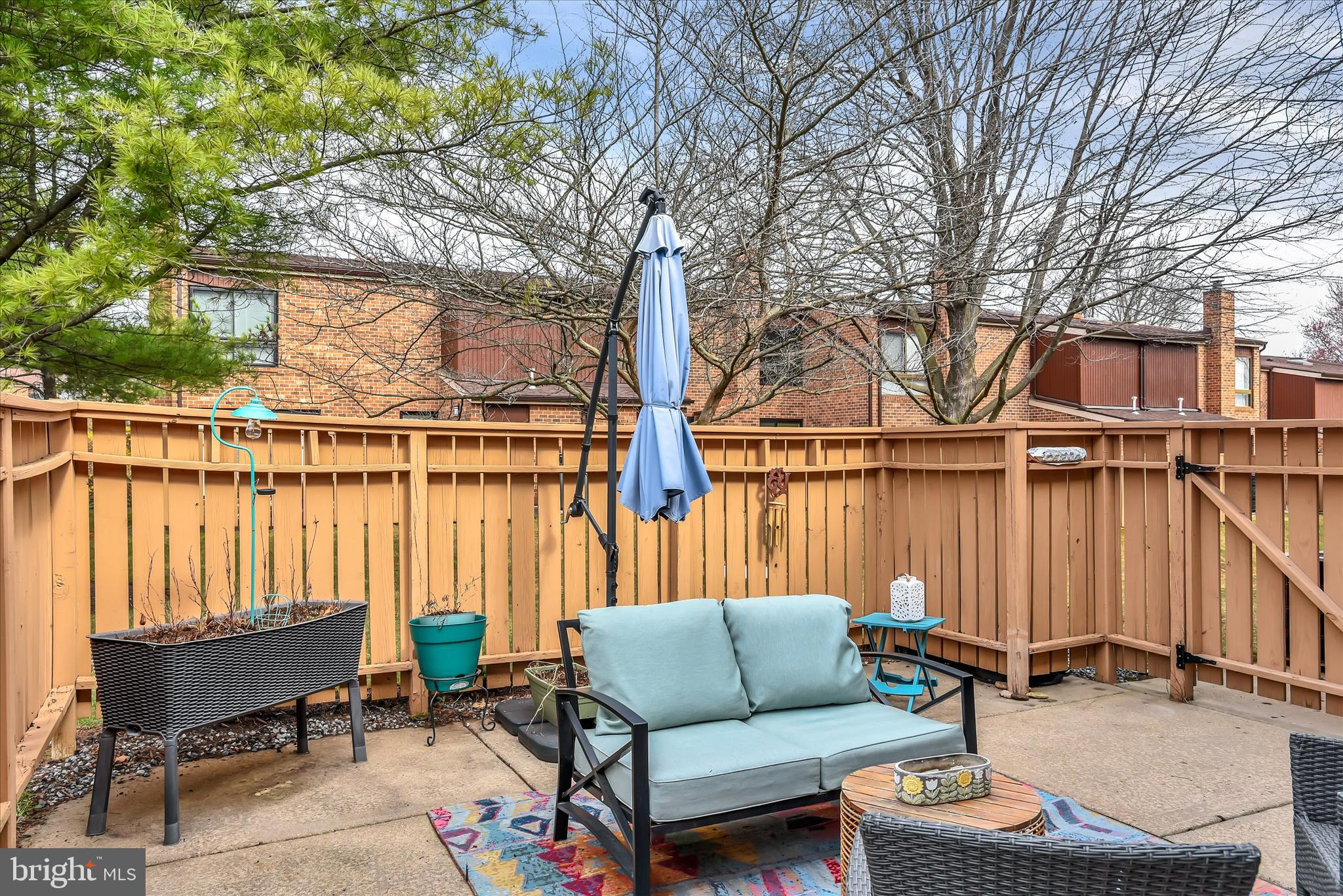 41 Stirrup Court, Unit 7 Baltimore, MD 21208 - Photo 24 of 34 a view of a patio with couches and a table and chairs with wooden floor and fence