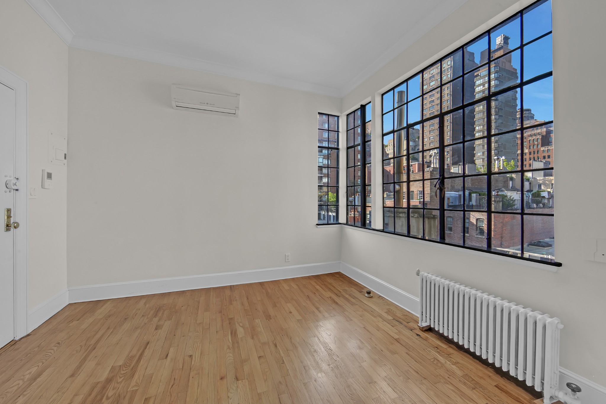 127 East 69th Street, Unit PH Manhattan, NY 10021 - Photo 2 of 11 a view of an empty room with wooden floor and a window