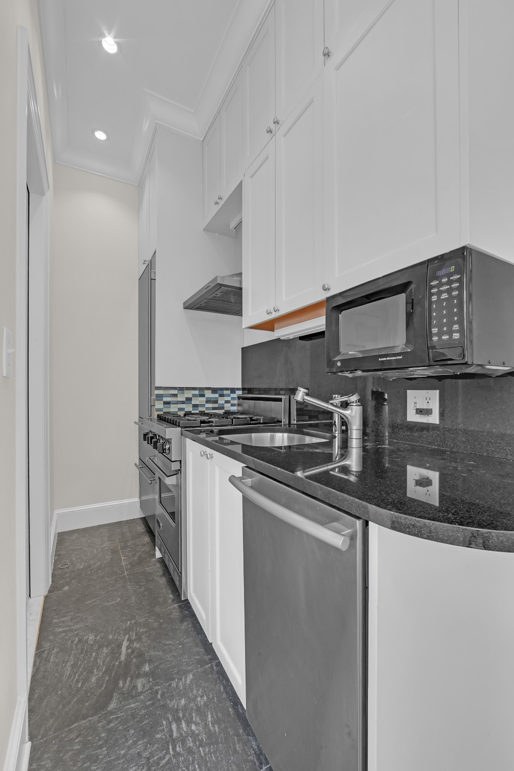 127 East 69th Street, Unit PH Manhattan, NY 10021 - Photo 4 of 11 a kitchen with stainless steel appliances granite countertop a sink stove and cabinets