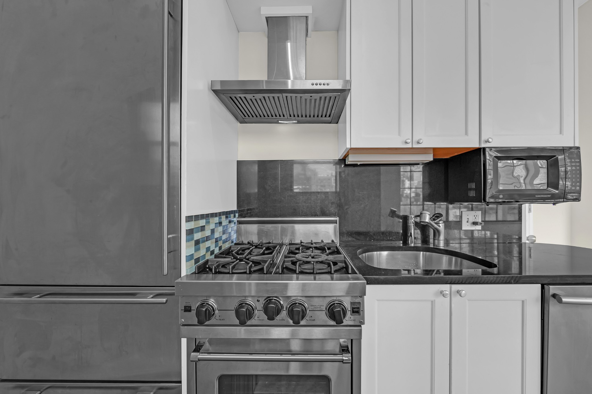 127 East 69th Street, Unit PH Manhattan, NY 10021 - Photo 5 of 11 a kitchen with granite countertop a stove and a white cabinets