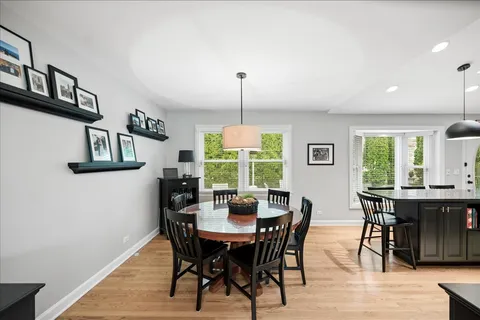 a living room with stainless steel appliances kitchen island granite countertop a dining table chairs and a living room view