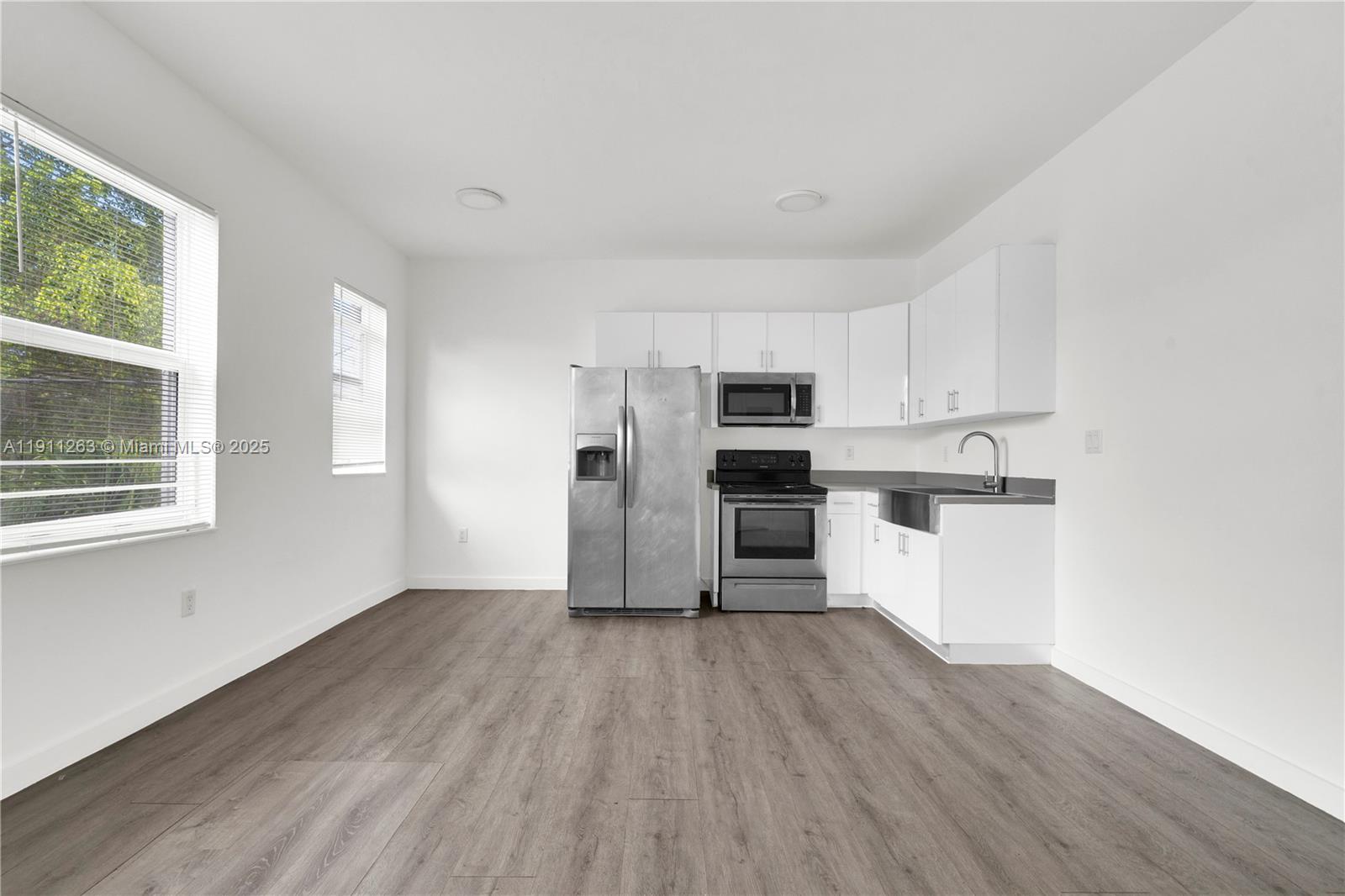 402 Northwest 12th Avenue, Unit 210 Miami, FL 33128 - Photo 2 of 16 a view of a kitchen with wooden floor and electronic appliances