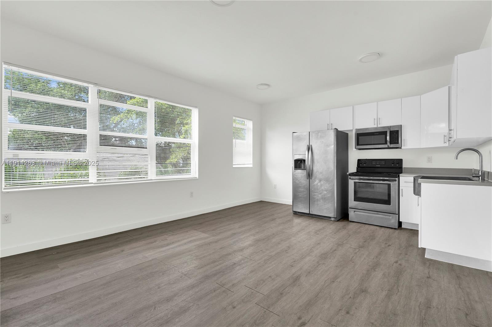 402 Northwest 12th Avenue, Unit 210 Miami, FL 33128 - Photo 4 of 16 a view of kitchen with wooden floor electronic appliances and windows