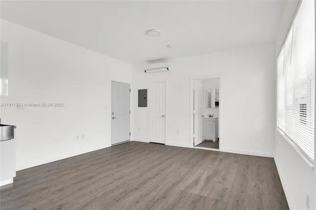 a view of a big room with wooden floor and windows in a room