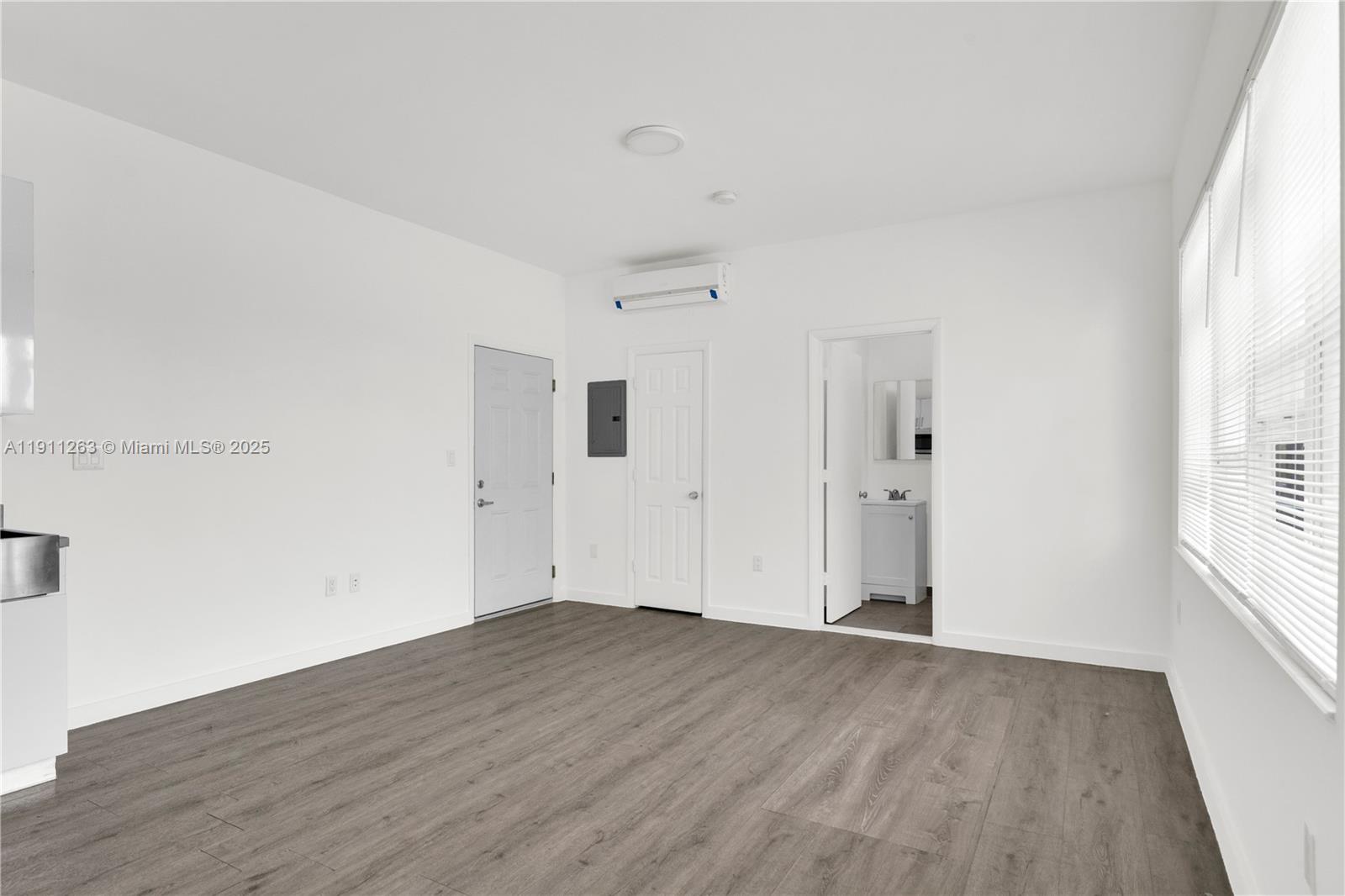 402 Northwest 12th Avenue, Unit 210 Miami, FL 33128 - Photo 6 of 16 a view of a big room with wooden floor and windows in a room
