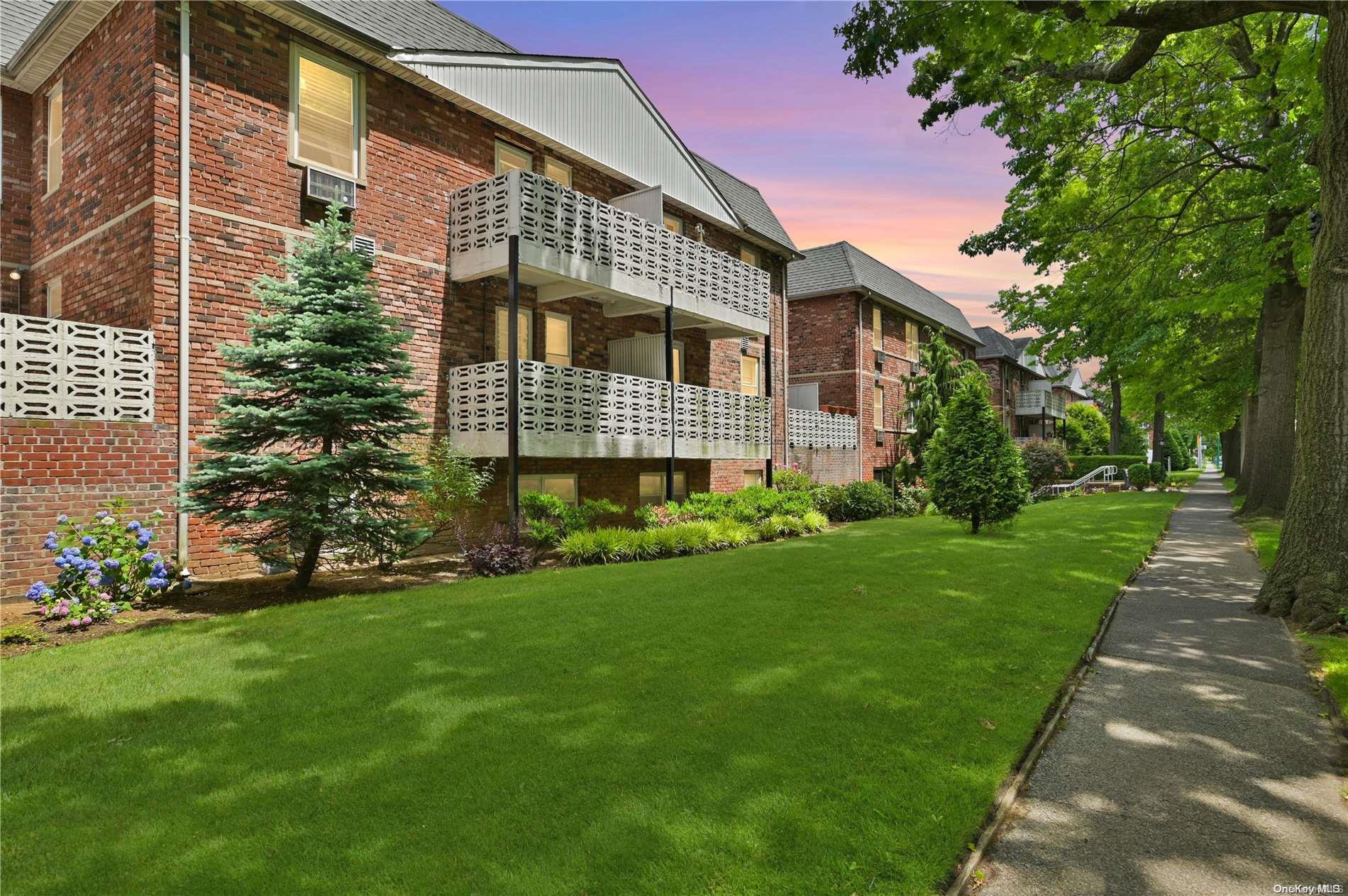40 Daley Place, Unit 232 Lynbrook, NY 11563 - Photo 1 of 1 a front view of a house with a garden