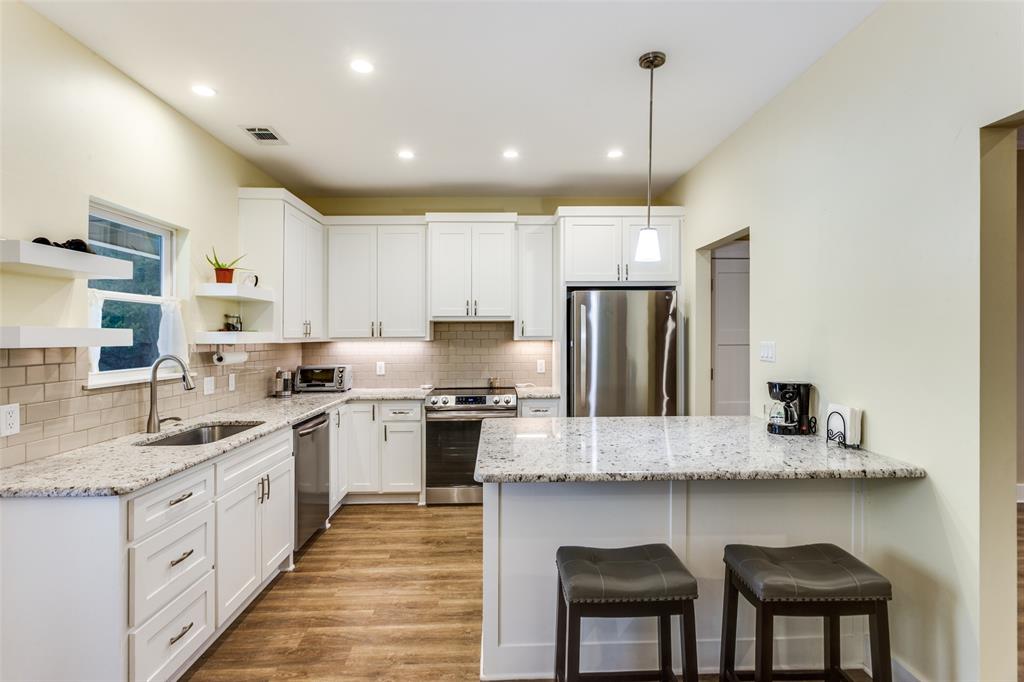 198 Fort Graham Whitney, TX 76692 - Photo 16 of 30 a large kitchen with granite countertop lots of counter space white cabinets and stainless steel appliances