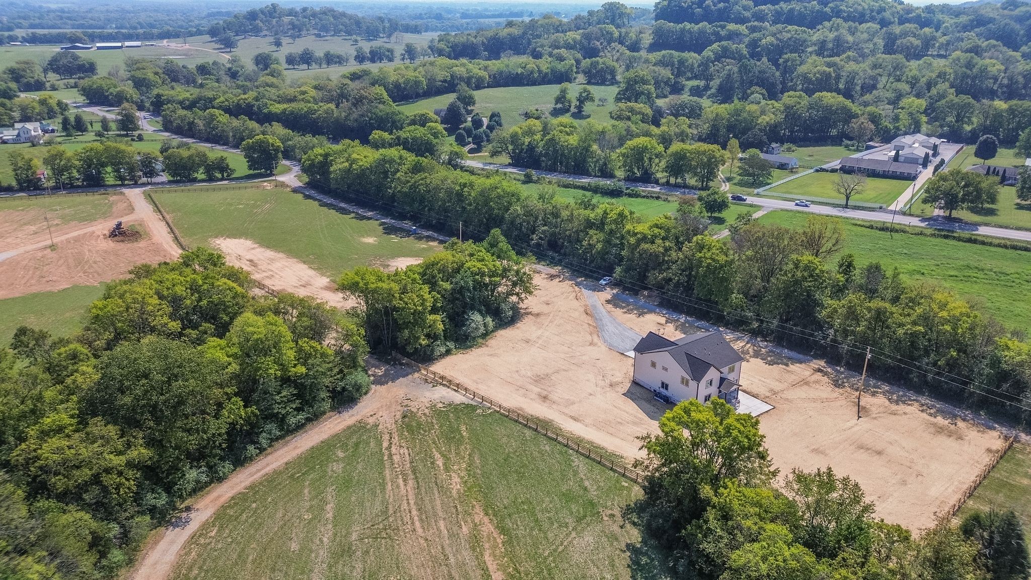 an aerial view of a house with a yard and lake view