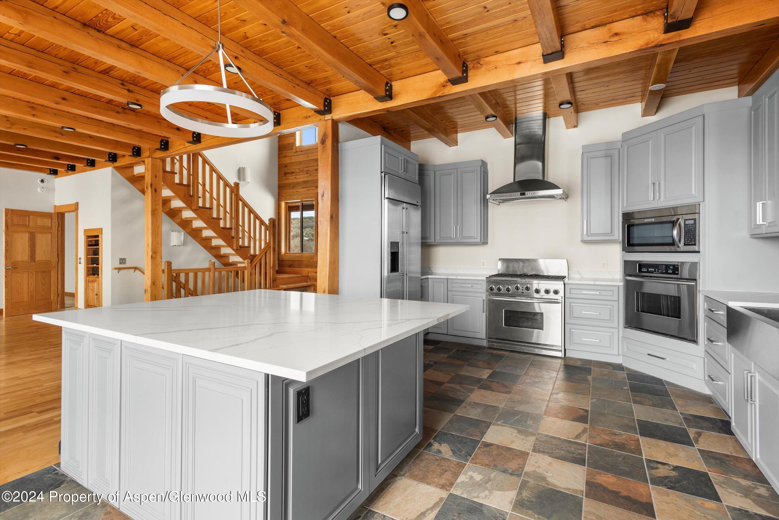 303 Park Meadows Lane Carbondale, CO 81623 - Photo 12 of 47 a kitchen with stainless steel appliances kitchen island granite countertop a sink a stove and cabinets