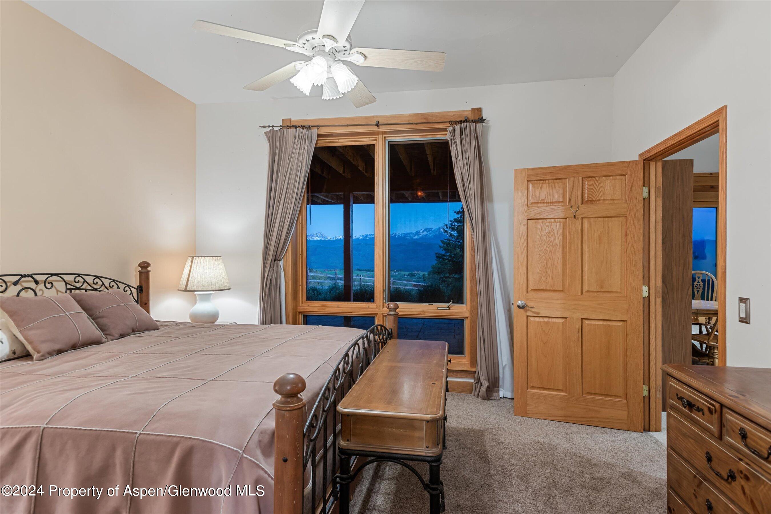 303 Park Meadows Lane Carbondale, CO 81623 - Photo 21 of 47 a bedroom with a bed and a chandelier