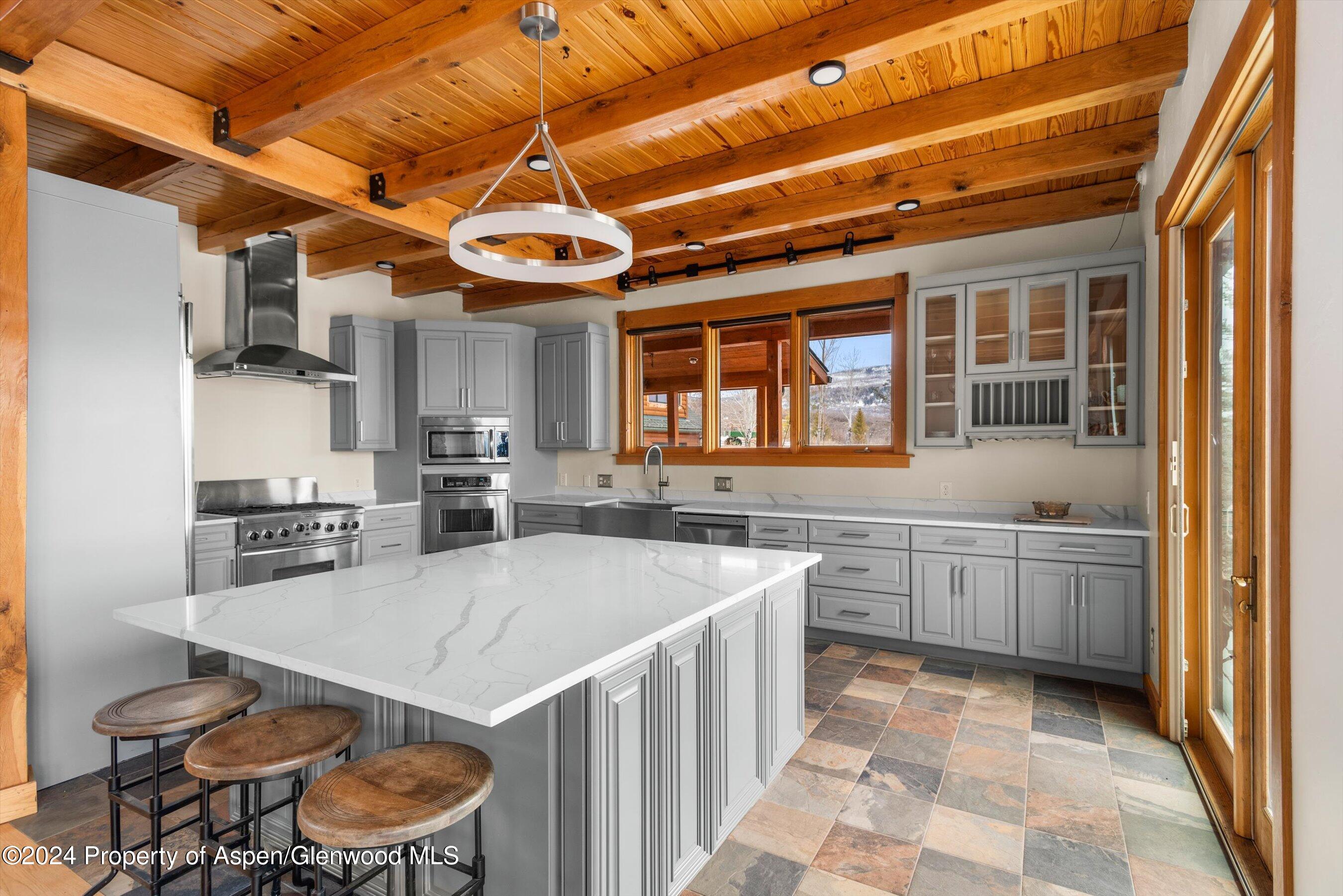 303 Park Meadows Lane Carbondale, CO 81623 - Photo 10 of 47 a kitchen with a stove a sink a refrigerator and wooden cabinets