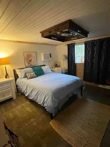 a bedroom with a bed a couch and ceiling fan