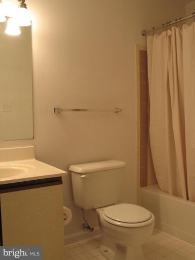4932 Columbia Road, Unit 7 Columbia, MD 21044 - Photo 10 of 19 a white toilet sitting next to a shower curtain