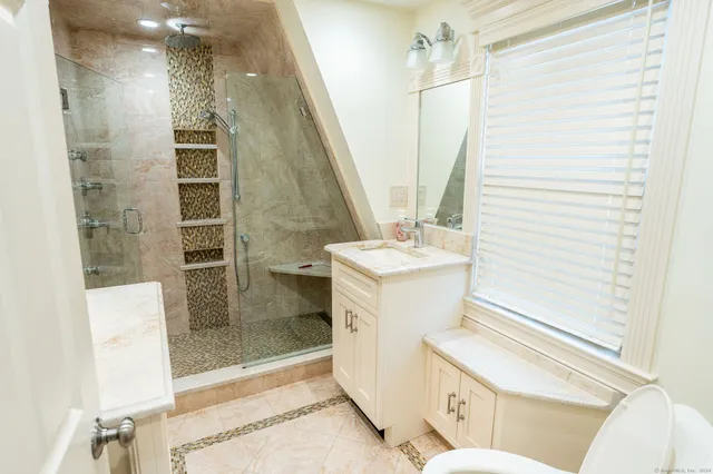 a bathroom with a sink a toilet and shower