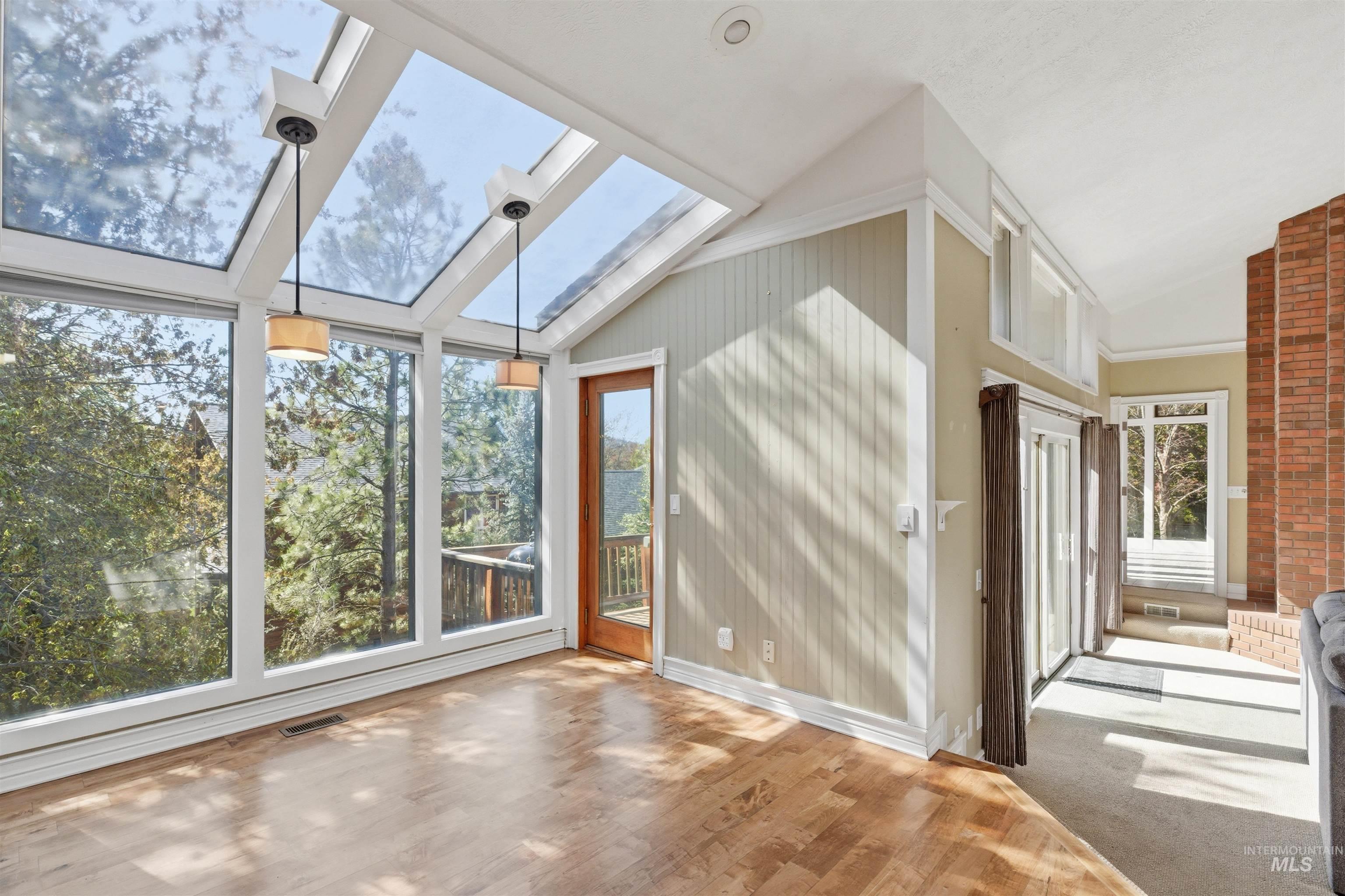 1540 Pine Cone Road Moscow, ID 83843 - Photo 11 of 49 Room with extensive window walls, two skylights, and wood-finish flooring