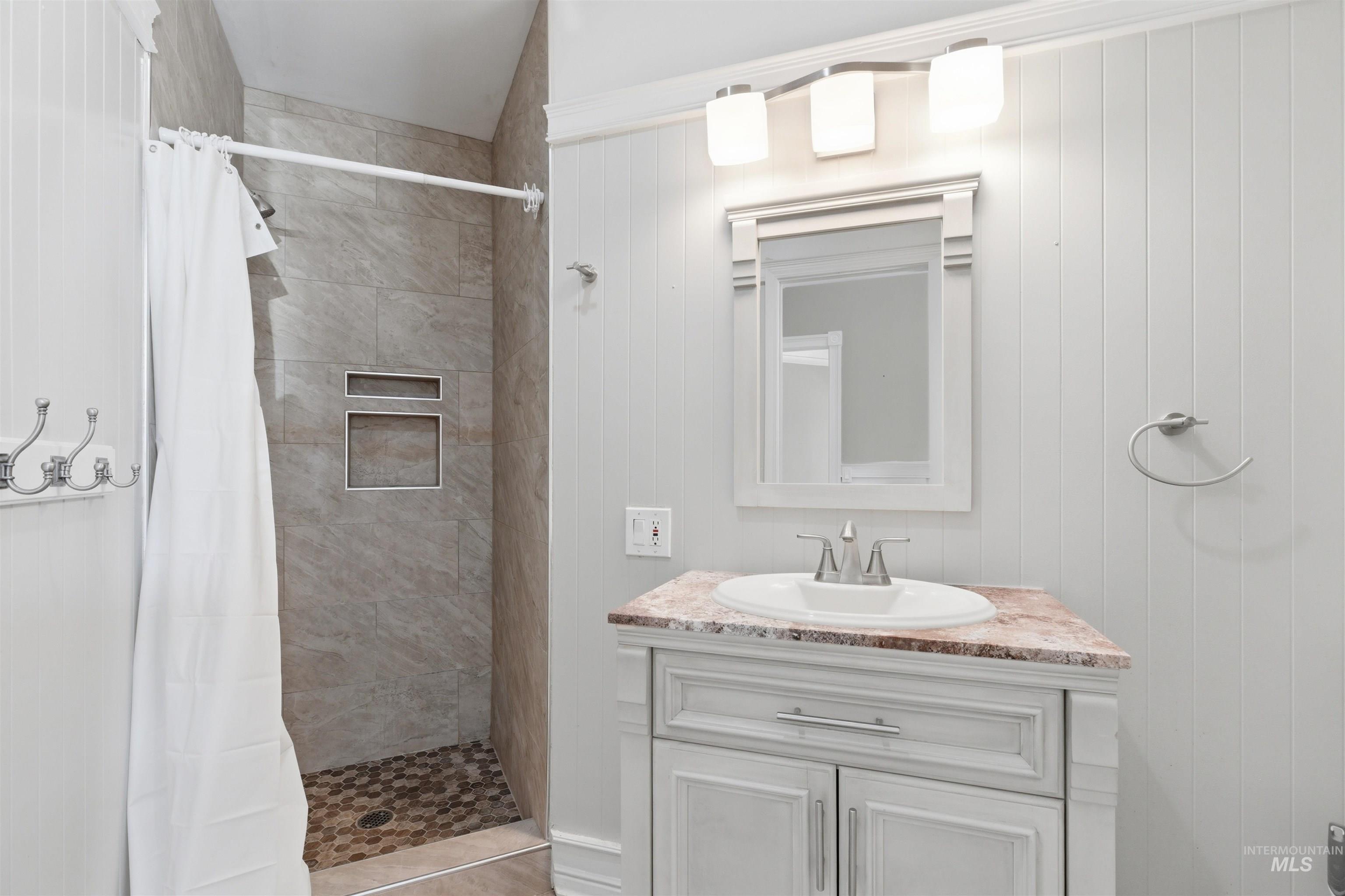 1540 Pine Cone Road Moscow, ID 83843 - Photo 22 of 49 Bathroom featuring a tiled shower with recessed niches and a pebble-style floor