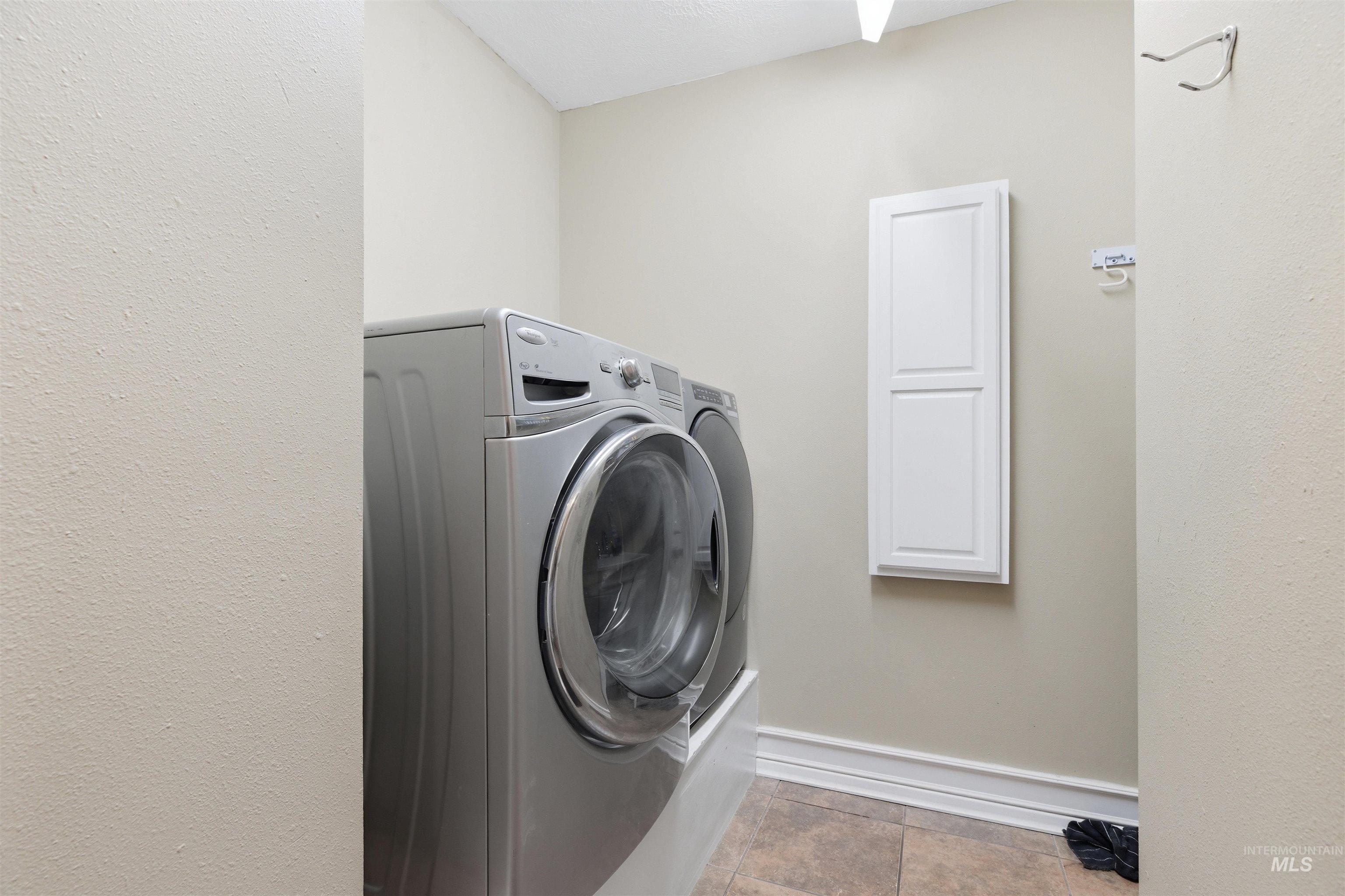 1540 Pine Cone Road Moscow, ID 83843 - Photo 23 of 49 Dedicated laundry area featuring neutral-toned walls, tile flooring, and a built-in white cabinet for storage