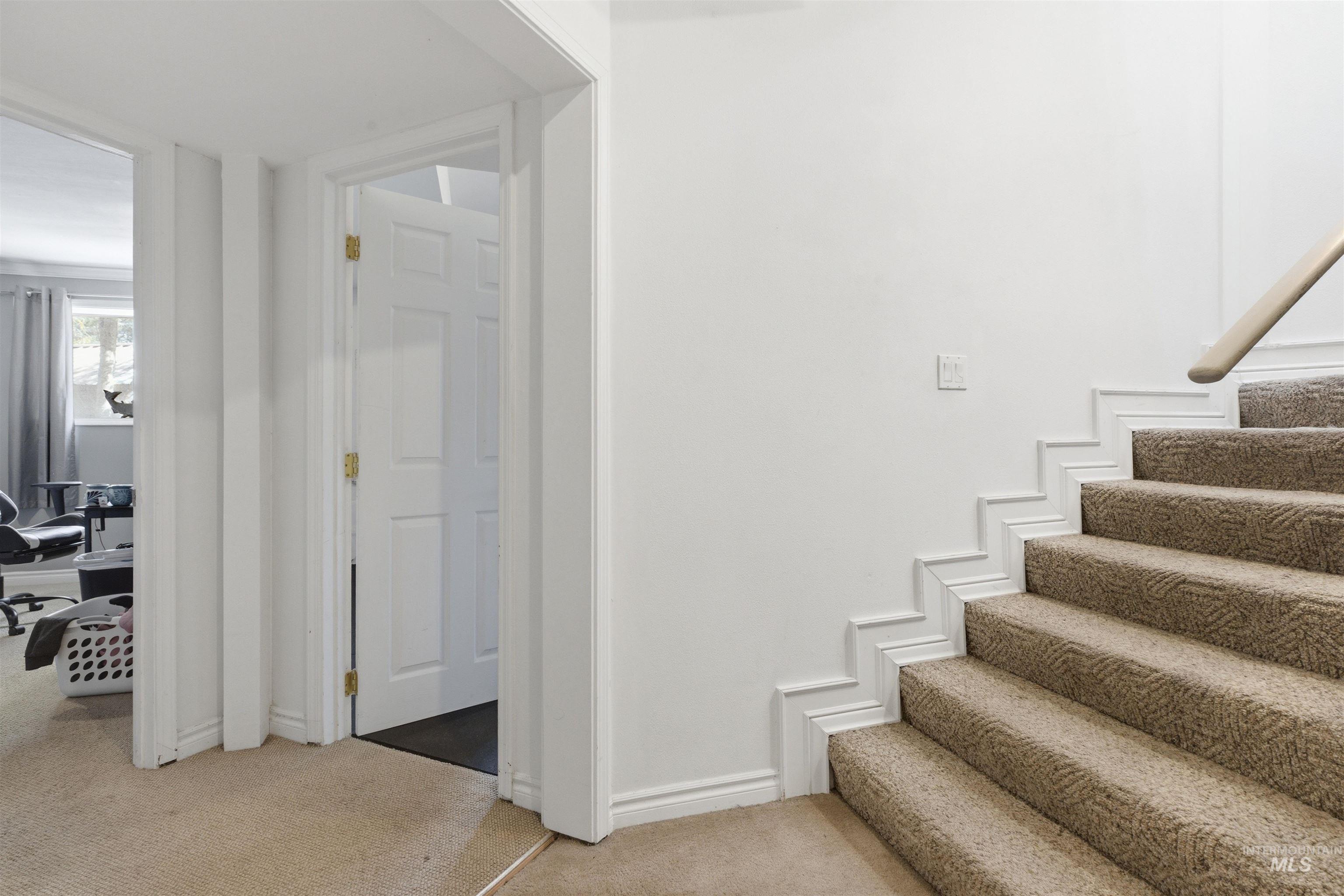 1540 Pine Cone Road Moscow, ID 83843 - Photo 25 of 49 Carpeted staircase with white trim detailing and a light wood handrail