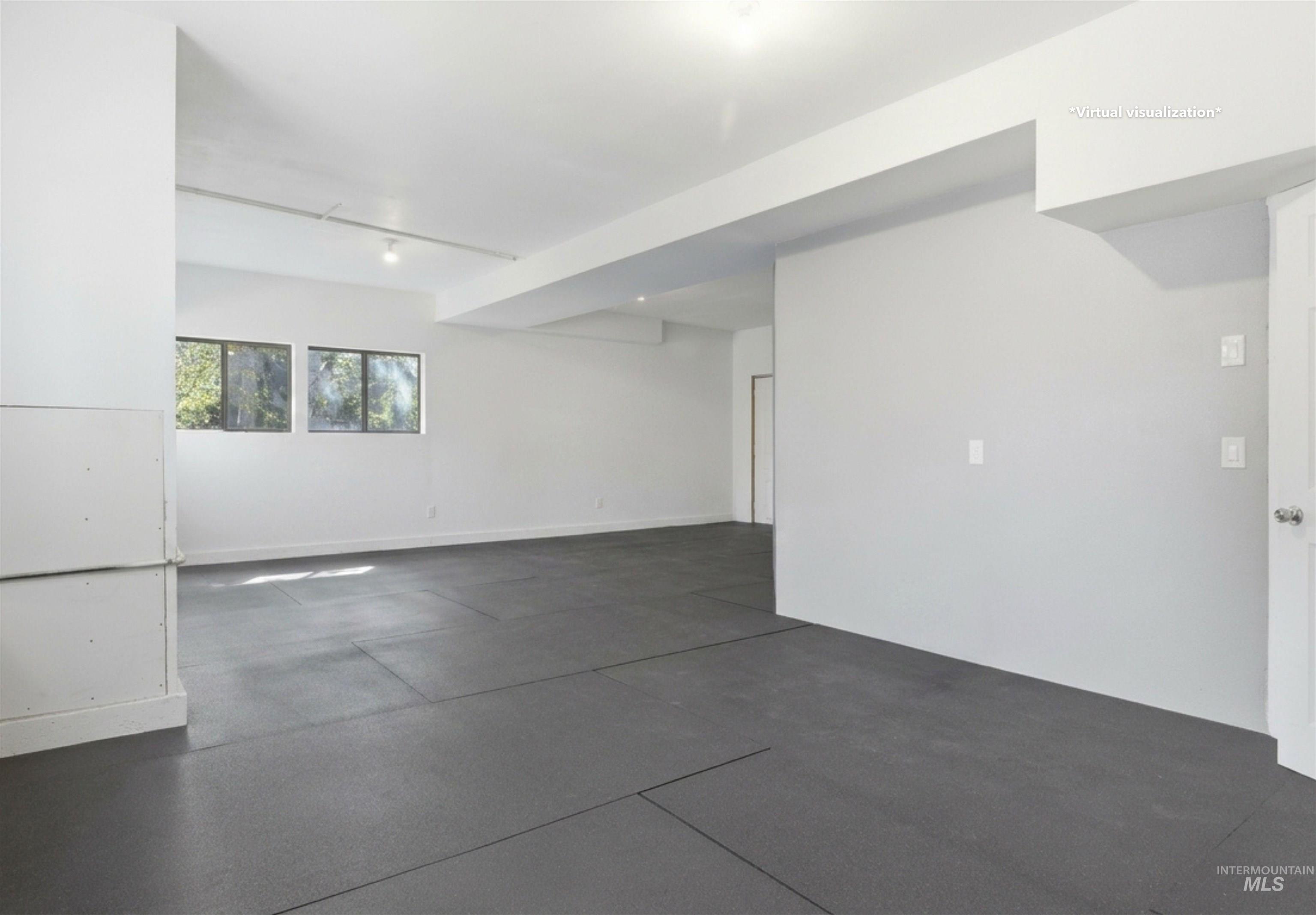 1540 Pine Cone Road Moscow, ID 83843 - Photo 27 of 49 Spacious room with dark-toned flooring, white walls, and two visible windows