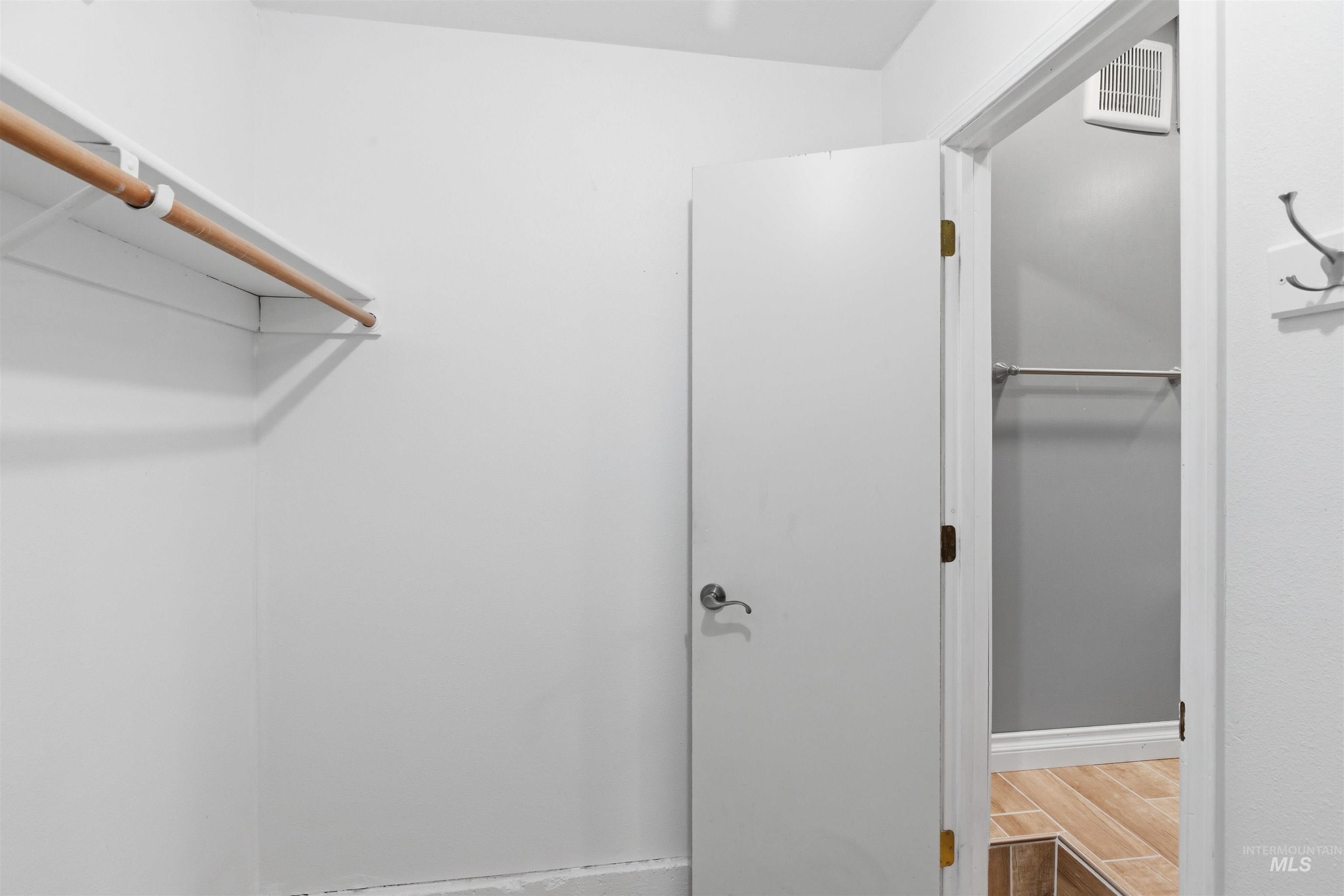 1540 Pine Cone Road Moscow, ID 83843 - Photo 33 of 49 White closet space featuring a wooden hanging rod, an additional hanging rod, and a built-in wall hook rack