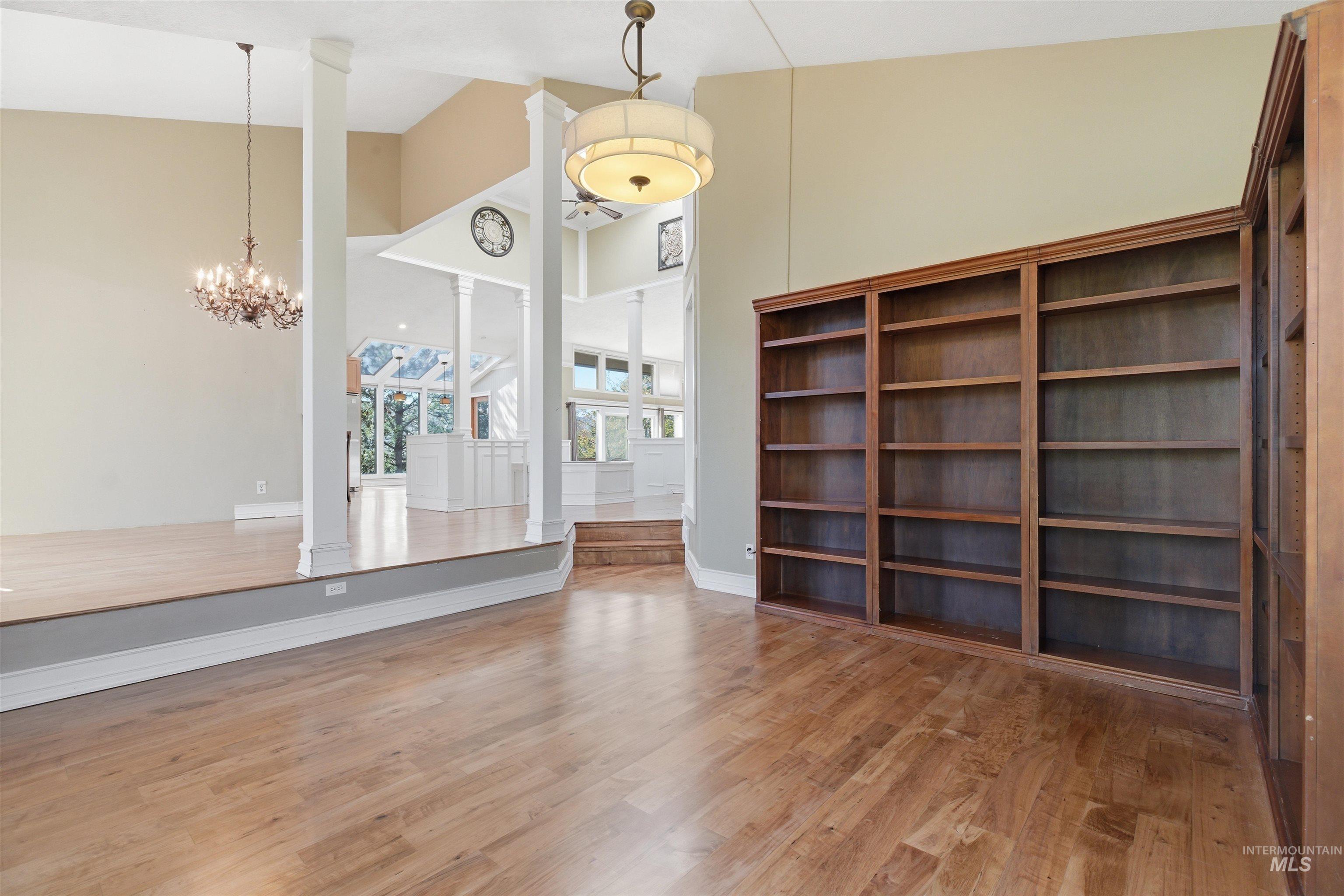 1540 Pine Cone Road Moscow, ID 83843 - Photo 5 of 49 Built-in wood shelving units, wood-finish flooring, and a contemporary drum pendant light
